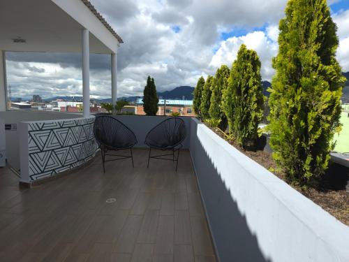 two chairs on the balcony of a house at Estainn Hotel Coworking in Bogotá