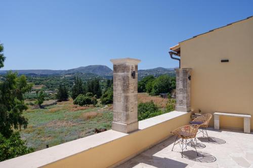 a balcony with two chairs and a view of the mountains at New Private Apartments by Myre3, just a short drive from Rethymno and the beach in Zourídhion