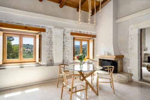 a dining room with a table and chairs and a fireplace at New Private Apartments by Myre3, just a short drive from Rethymno and the beach in Zourídhion