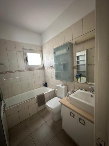 a bathroom with a toilet and a tub and a sink at Villa Serenity in Protaras
