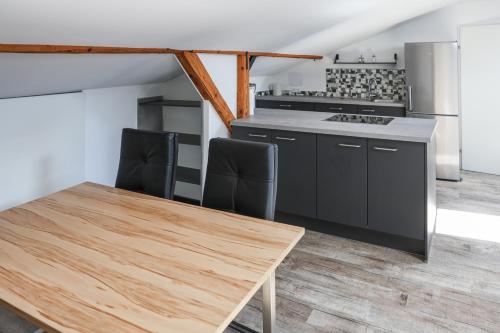 a kitchen with a wooden table and black cabinets at Haus Forsthuber in Gasthof