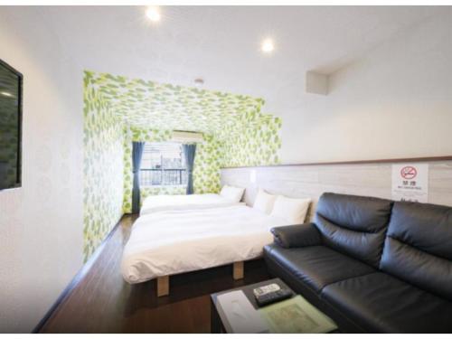 a living room with a couch and a bed at R Hotel - Vacation STAY 19691 in Chiba