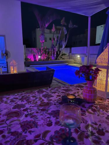 a table with a vase of flowers and a pool at Villa Serenity in Protaras
