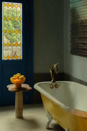 a bath tub in a bathroom with a window at Maison Lezard in Mexico City