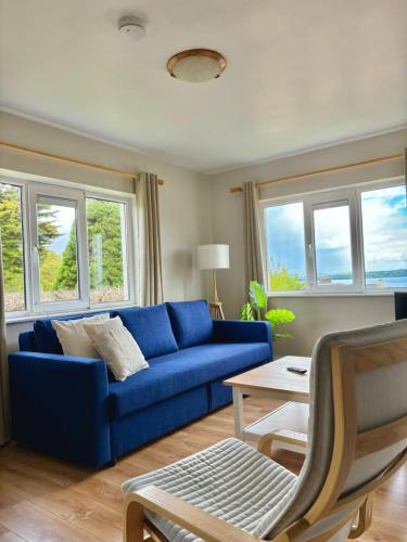 a blue couch in a living room with windows at Cathedrals Corner Cobh in Cobh