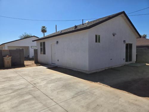 a large white building with a garage at Casita in back house Not a hotel shared living in Glendale