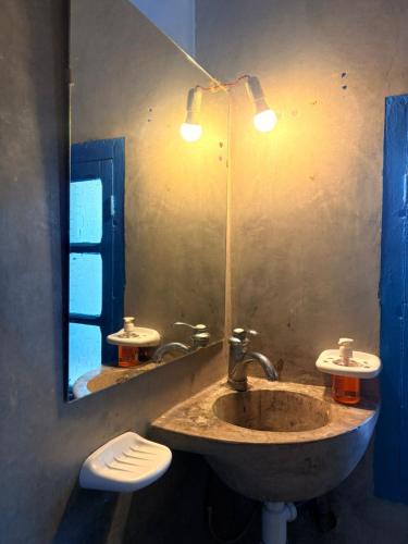 a bathroom with a sink and a mirror at ASARAG GUEST HOUSE & Lodge in Mirleft