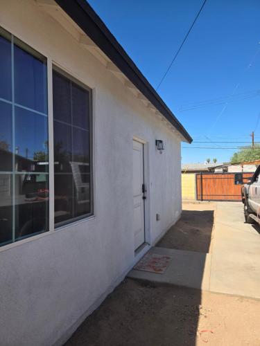 a white building with a door on the side of it at Casita in back house Not a hotel shared living in Glendale