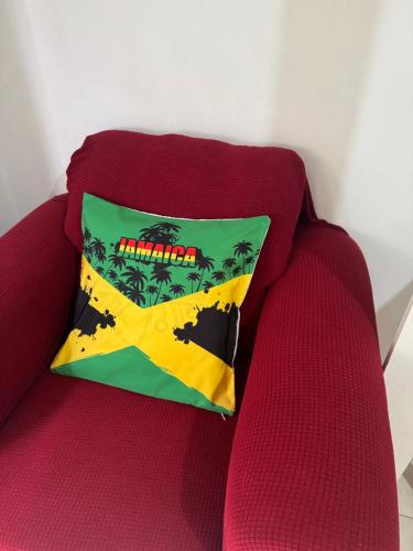 a pillow sitting on top of a red couch at Pearl of the City JAMAICA PEARL in Kingston