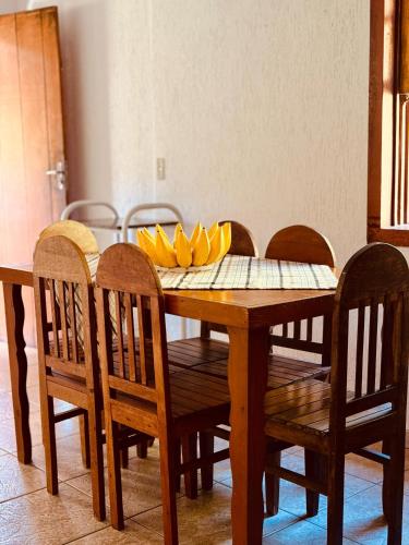 a wooden table with chairs and bananas on it at Casa Cida Guimarães in Prados