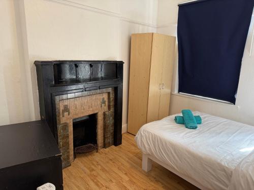 ロンドンにあるRahal Hotel Hackney Londonの暖炉とベッドのある部屋、そしてベッドsidx sidx sidx