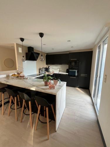 a kitchen with a large island in a kitchen with black cabinets at Au coeur du Ried 