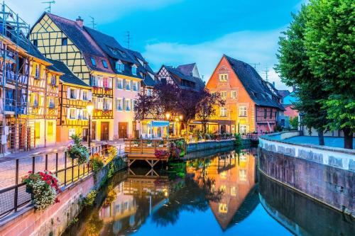 a group of buildings next to a river at Au coeur du Ried 