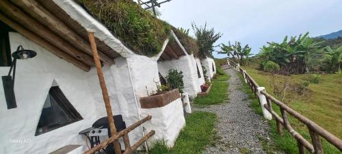 a white building with plants on the side of it at Hobbit Hotel El peñol Guatapé in La Pradera