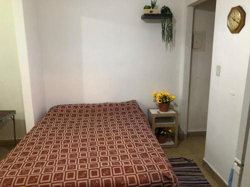 a bedroom with a bed and a table and a clock at Departamento Adrián Mar del Plata Bs As in Mar del Plata