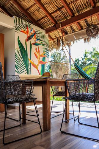 a table and chairs with a painting on the wall at Apartment Lodge Tres Palmas. Apartment #1 in Temalhuacán