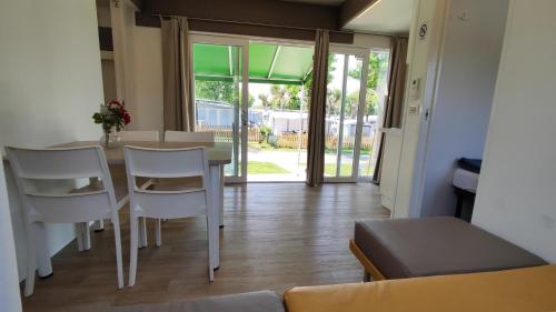 a living room with a table and white chairs at Campeggio del Garda in Peschiera del Garda