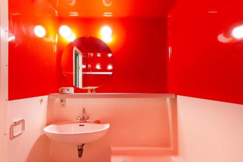 a red bathroom with a sink and a mirror at Résidence Nova 3 - Appartement 2 pièces 6 personnes proche des pistes MAE-8014 in Arc 1800