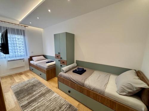 a small bedroom with two beds and a mirror at Mount Inn Desetka in Zlatibor