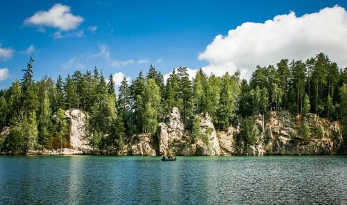 a boat in the middle of a lake with trees at Adrspach family apartment in Teplice nad Metují