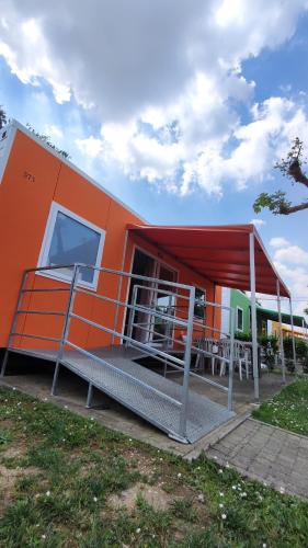 an orange house with awning and tables in front of it at Campeggio del Garda in Peschiera del Garda