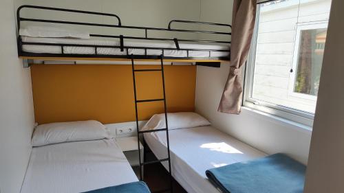 two bunk beds in a small room with a window at Campeggio del Garda in Peschiera del Garda