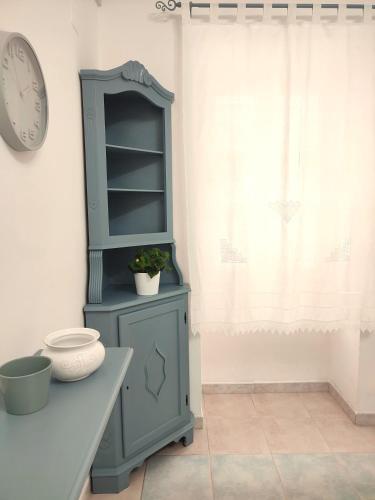 a blue cabinet sitting next to a table with a clock at Casa logudoro 7 in Sorso