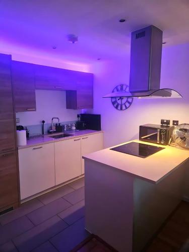 a kitchen with purple lighting and a kitchen counter at Executive E15 Apartment - Skyline Terrace & Free Private Parking - 5-min Walk to Abba Arena in London