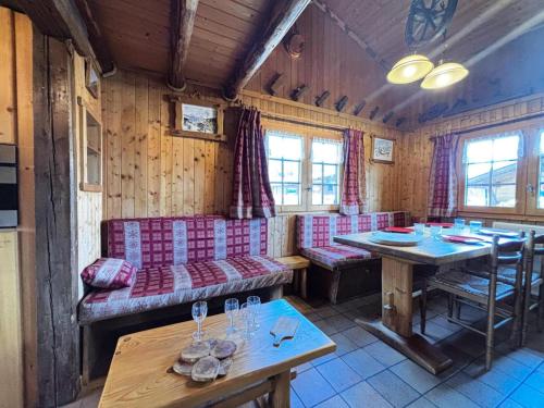 Cette chambre comprend une table, un canapé, une table et des chaises. dans l'établissement Résidence Tavaillon - Chalet savoyard cosy centre village MAE-5161, à Notre-Dame-de-Bellecombe