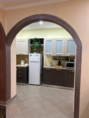 an arched kitchen with a white refrigerator at B&B Il Cuore del Borgo in Papasidero