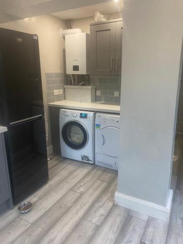 a kitchen with a washing machine and a washer at Fully refurbished house Belfast in Belfast