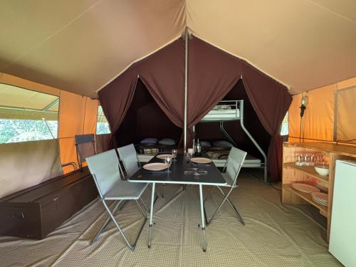 une tente avec une table et des chaises à l'intérieur dans l'établissement Camping Onlycamp de Tignes, à Tignes