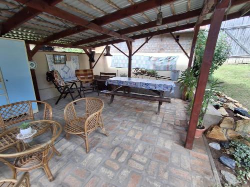 a patio with chairs and a table and a bench at Téli Berek Vendégház in Abod