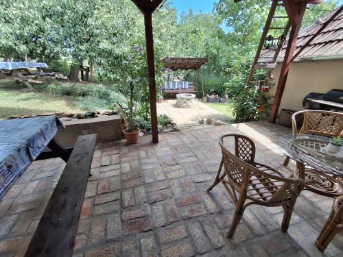 a patio with a table and chairs and a table and a table and chairs at Téli Berek Vendégház in Abod