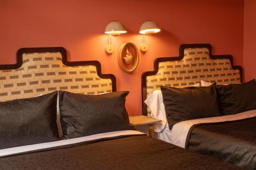two beds in a room with orange walls at Maison Lezard in Mexico City