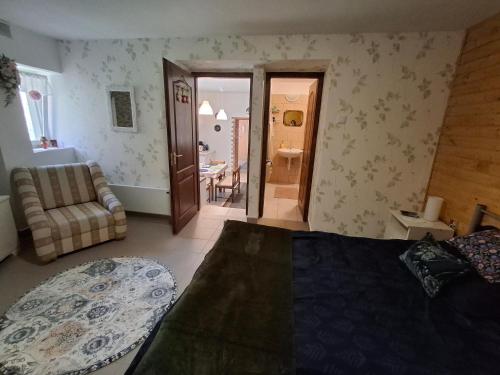 a bedroom with a bed and a living room at Téli Berek Vendégház in Abod