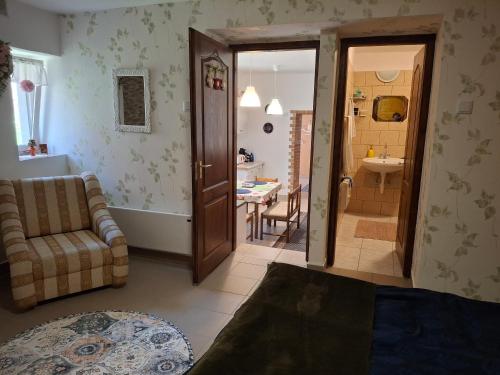 a living room with a couch and a bathroom at Téli Berek Vendégház in Abod