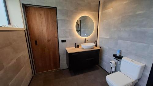 a bathroom with a sink and a toilet and a mirror at B&B Aquamarijn Katwijk in Katwijk aan Zee