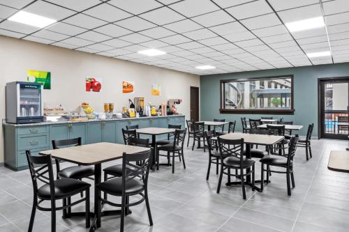 a dining room with tables and chairs and a counter at Quality Inn Harvey - New Orleans in Harvey