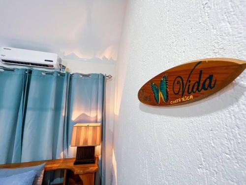 a surfboard on the wall of a bedroom at Villa Coco 55, Few Steps from beach and Free Wifi in Jacó
