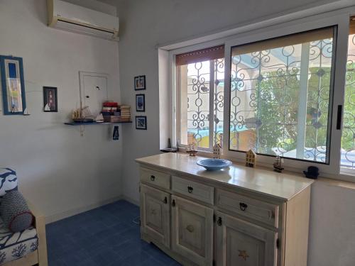 a room with a window and a wooden dresser with a counter at Villa Mayla in Ippocampo
