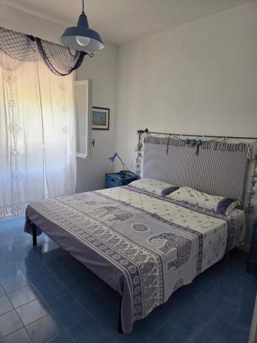 a bedroom with a large bed with a blanket on it at Villa Mayla in Ippocampo
