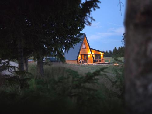 a small wooden house with lights on it at night at Vila Vida in Žabljak
