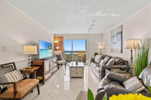 a living room with a couch and a tv at Sea Pointe 507 - Oceanfront in Myrtle Beach
