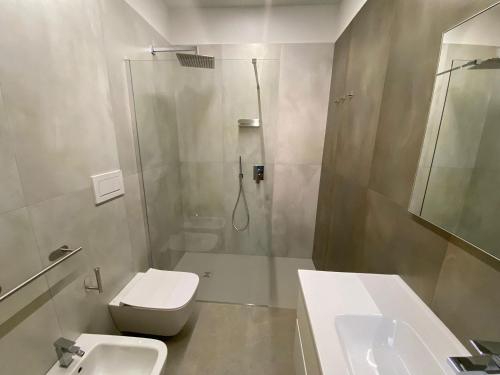 a bathroom with a shower and a toilet and a sink at L'Altalena Guest House in Lido Di Fondi