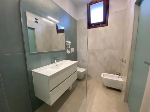 a bathroom with a sink and a toilet and a mirror at L'Altalena Guest House in Lido Di Fondi