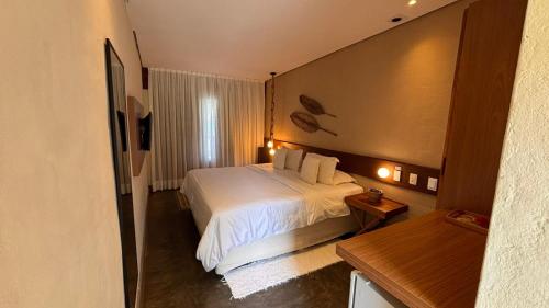 a hotel room with a bed and a window at Hotel da Pipa in Pipa