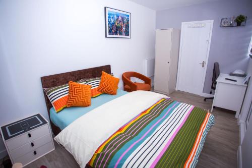 a bedroom with a large bed with colorful pillows at Modern Serenity 1 Bedroom Stay in Tilbury