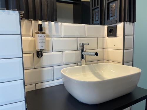 a bathroom with a sink and a bottle of soap at Mickitos Urban Hostel in Skopje