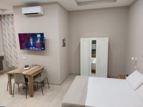 a bedroom with a table and a bed and a table and chairs at Dimora Tulliano in Manfredonia